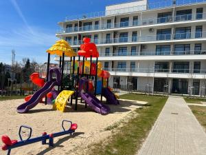 a playground in the sand in front of a building at Apart Premium Ku Morzu in Sianozety