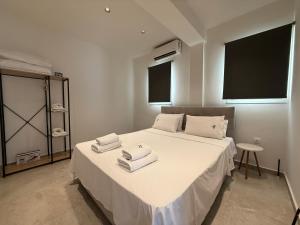 a bedroom with a white bed with towels on it at K78 Studios B1 in Nea Michaniona