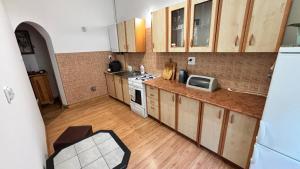 a kitchen with wooden cabinets and a white stove top oven at Friendly House in Bolesławiec +4 photos