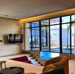 a living room with a swimming pool in a house at The W Luxury Chalet in Salalah