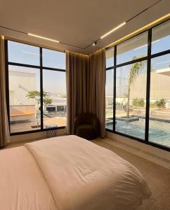 a bedroom with a bed and a large window at The W Luxury Chalet in Salalah