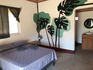 a bedroom with a bed with a painting on the wall at Thirstybeaver in Playa Santana