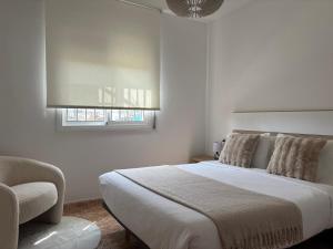 a bedroom with a bed and a chair and a window at La caseta del canal in Deltebre +46 photos