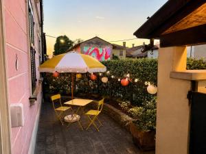 a table and chairs with an umbrella on a patio at B&B La Borasca - Apartments in Casalpusterlengo