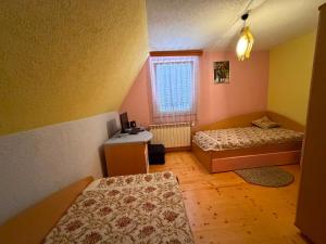 a small room with two beds and a desk at Villa Tara in Gostivar
