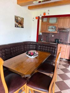 a kitchen with a wooden table with a bowl of flowers on it at Villa Tara in Gostivar