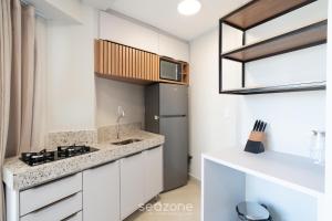a kitchen with white cabinets and a counter top at Studio in Condo. w/ Pool in Downtown MSU0406 in Governador Valadares