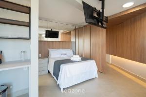 a bedroom with a bed and a television in it at Studio in Condo. w/ Pool in Downtown MSU0406 in Governador Valadares +2 photos