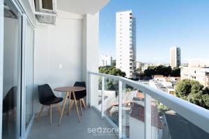 a balcony with two chairs and a table on a building at Studio in Condo. w/ Pool in Downtown MSU0406 in Governador Valadares