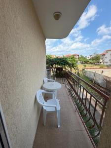 a balcony with a table and two white chairs at Guest House Dayana Apartment 2 in Ravda