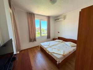 a bedroom with a bed and a window at Guest House Dayana Apartment 2 in Ravda