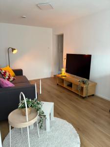 a living room with a couch and a flat screen tv at VITA Apartment in Herrenberg