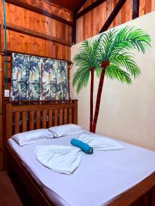 a bedroom with a bed with a palm tree at La Orquídea Cabañas in Playa Ladrilleros