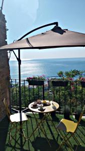 a table and chairs under an umbrella on a balcony at Al vecchio Incasato in Grottammare