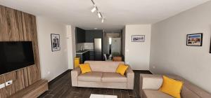 a living room with a couch and a flat screen tv at Sandy Vibes Apartments in Durrës