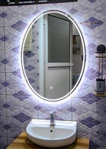 a bathroom with a sink and a mirror at La Cas'a Yehud in Aoudja +12 photos