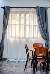 a table and chairs in front of a window at La Cas'a Yehud in Aoudja