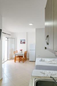 a kitchen and dining room with two beds and a table at Nefeli apartments in Borsh