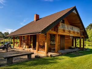 a log cabin with a bench in front of it at Kāpas Wood house in Uguņi