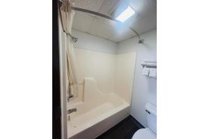 a bathroom with a bath tub and a sink at Rockwood Inn Kennett I 55 Near Blytheville in Kennett +49 photos