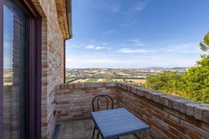 a bench on a brick balcony with a view at Lucciole e Lavanda BeB in Macerata