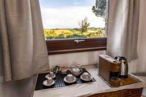 a coffee maker and cups on a table with a window at Lucciole e Lavanda BeB in Macerata +37 photos