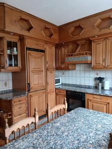a kitchen with wooden cabinets and a granite counter top at A Lucita-Ribeira Sacra in Rubiacós