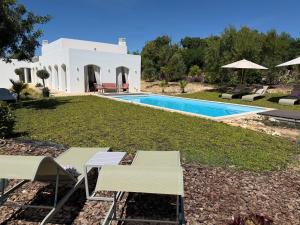 a villa with a swimming pool and a yard at Boutique Guesthouse-Moncarapacho in Moncarapacho