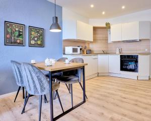 a kitchen and dining room with a table and chairs at Haus Schildt, FeWo 3 in Duhnen +14 photos