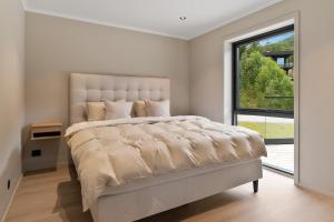 a bedroom with a large bed with a large window at Villa in Stryn in Stryn