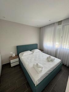 a bedroom with a large bed with towels on it at Sandy Vibes Apartments in Durrës