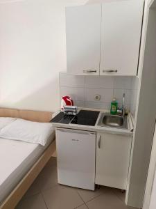 a small kitchen with a sink and white cabinets at Apartmani Šantić in Baška Voda +68 photos