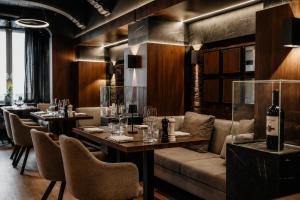 a restaurant with tables and chairs and wine bottles at Hotel Jensen in Lübeck