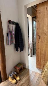 a hallway with shoes and a coat hanging on a wall at Chalé Roxo na Araucária in Gonçalves