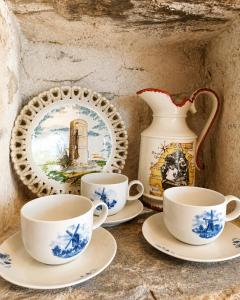 a group of tea cups and a vase on a counter at Le Moulin Neuf, logements atypiques dans le Pays d'Ancenis in Anetz
