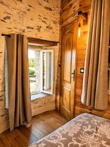 a bedroom with a bed and a window in a log cabin at Le Moulin Neuf, logements atypiques dans le Pays d'Ancenis in Anetz +67 photos