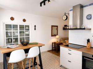 a kitchen with a wooden table and white cabinets at Casa Juana in Facinas