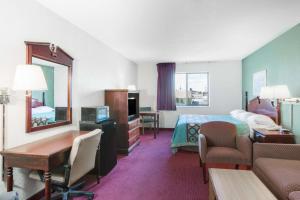 a hotel room with a bedroom with a bed and a mirror at Rockwood Inn Kennett I 55 Near Blytheville in Kennett