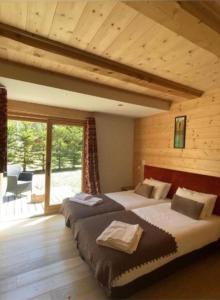 a bedroom with two beds in a log cabin at Chalet Isabelle Mountain lodge 5 stars 6 bedroom en suite sauna spa inox in Chamonix