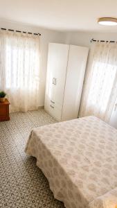 a bedroom with a bed and two white cabinets at Casa Juana in Facinas