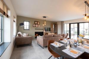 a living room with a table and chairs and a couch at Vakantiewoning Maison Chaperon in Wervik