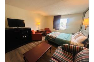 a hotel room with a bed and a couch at Rockwood Inn Kennett I 55 Near Blytheville in Kennett