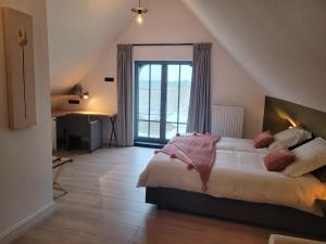 a bedroom with a bed and a desk and a window at Vakantiewoning Maison Chaperon in Wervik