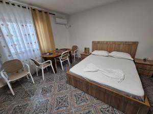 a bedroom with a bed and a table and chairs at Daja's Guest House in Shëngjin