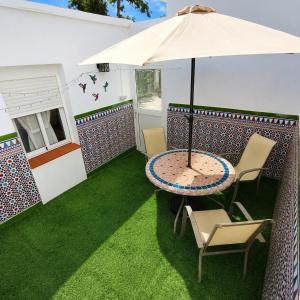 a patio with a table and chairs and an umbrella at Casa Juana in Facinas