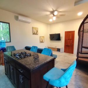 a living room with a table and blue chairs at KikiWitz Resort in Belmopan