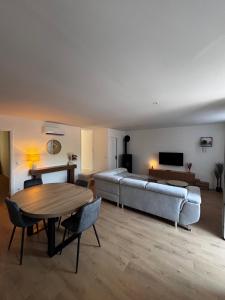 a living room with a couch and a table at Le Comptoir du Relais in Beine
