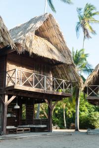 a resort with a thatched roof and palm trees at UNÚ Beach Hotel in Palomino +29 photos