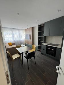 a kitchen and dining room with a table and chairs at Sandy Vibes Apartments in Durrës