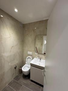 a bathroom with a toilet and a sink and a mirror at Sandy Vibes Apartments in Durrës +27 photos